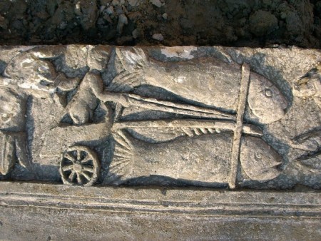 Particolare del fregio: due pesci aggiogati al carro guidato da un Amorino
