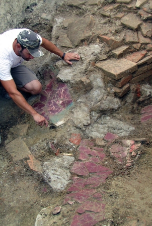 Un archeologo libera una parete affrescata del santuario di Montegibbio